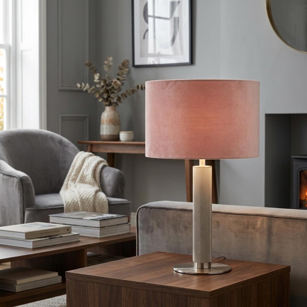 London Table Lamp with a knurled satin silver base and pink velvet shade on a wooden side table in a living room.