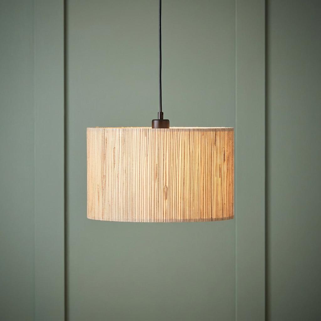 Longshore 1 light black ceiling pendant with a textured seagrass shade hanging against a green paneled wall.