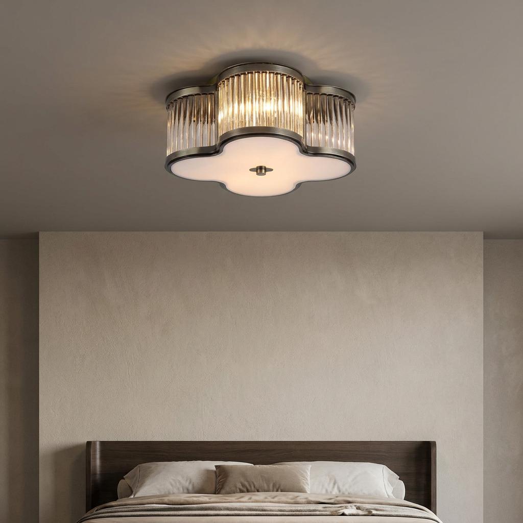 Lotus-shaped antique brass flush ceiling light with ribbed glass panels illuminates a modern bedroom.