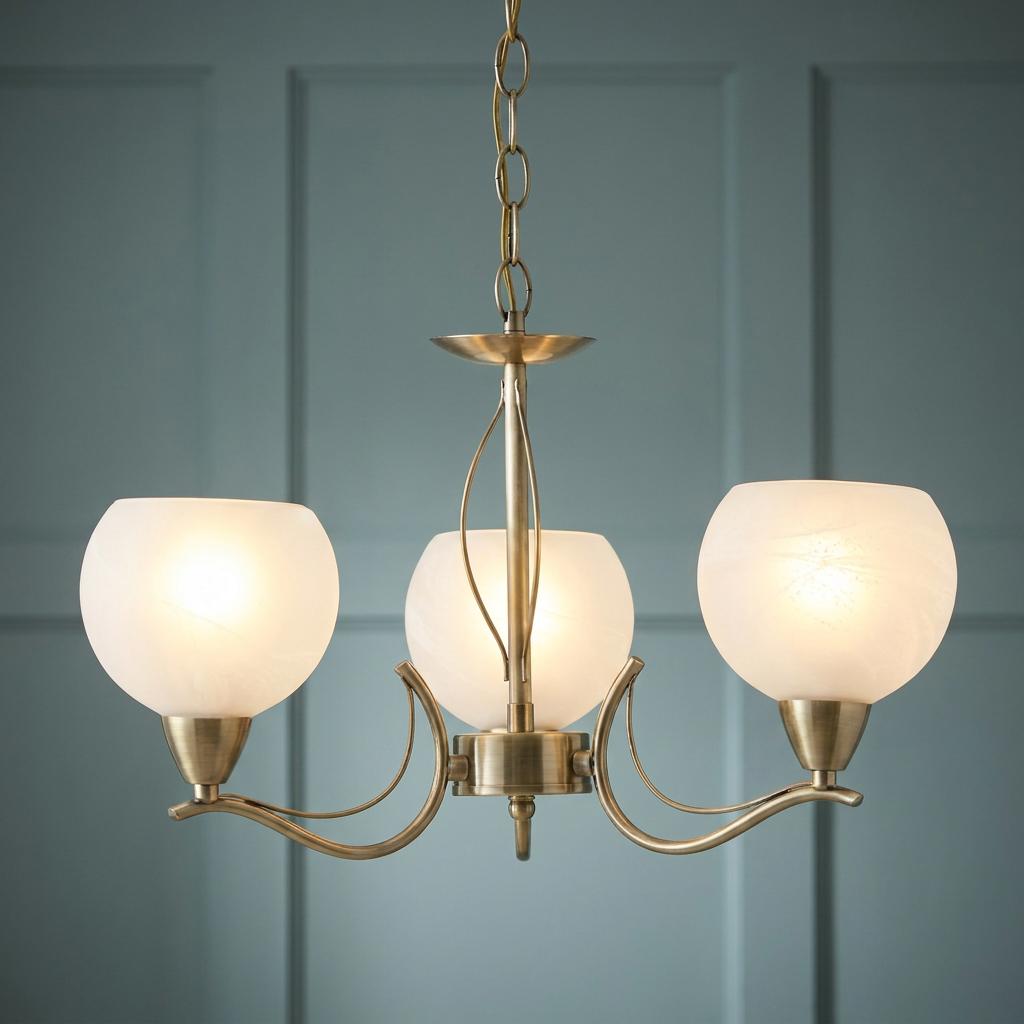 Three-light antique brass chandelier with frosted glass shades against a teal paneled wall.