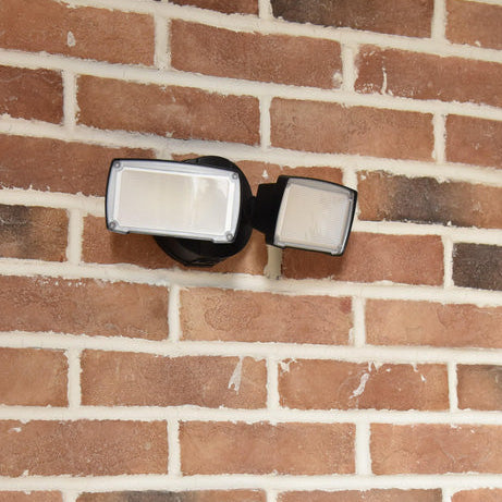 Outdoor security light fixture on a brick wall