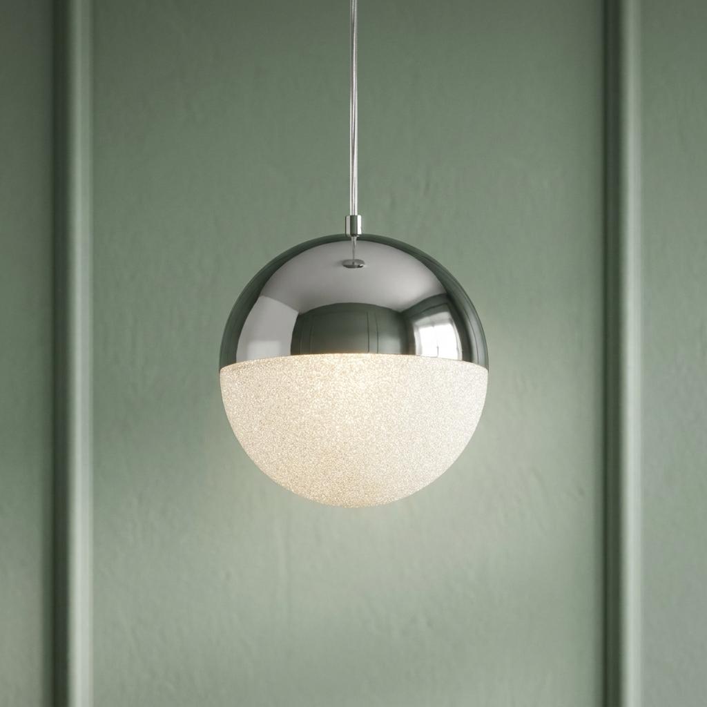 A Marbles 1 Light LED chrome and acrylic globe pendant light glowing against a sage green paneled wall.