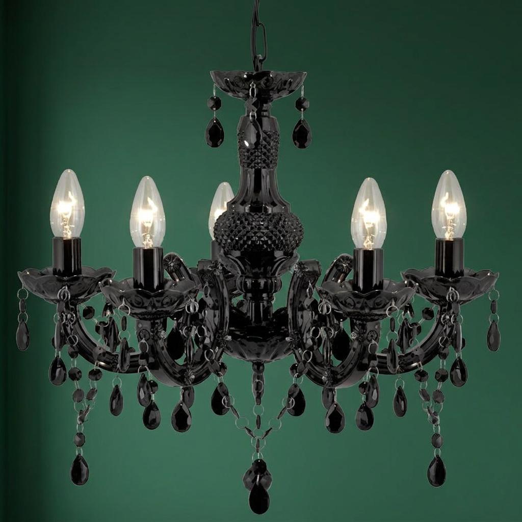 Black five-light Marie Therese chandelier with dangling glass droplets set against a dark green wall.