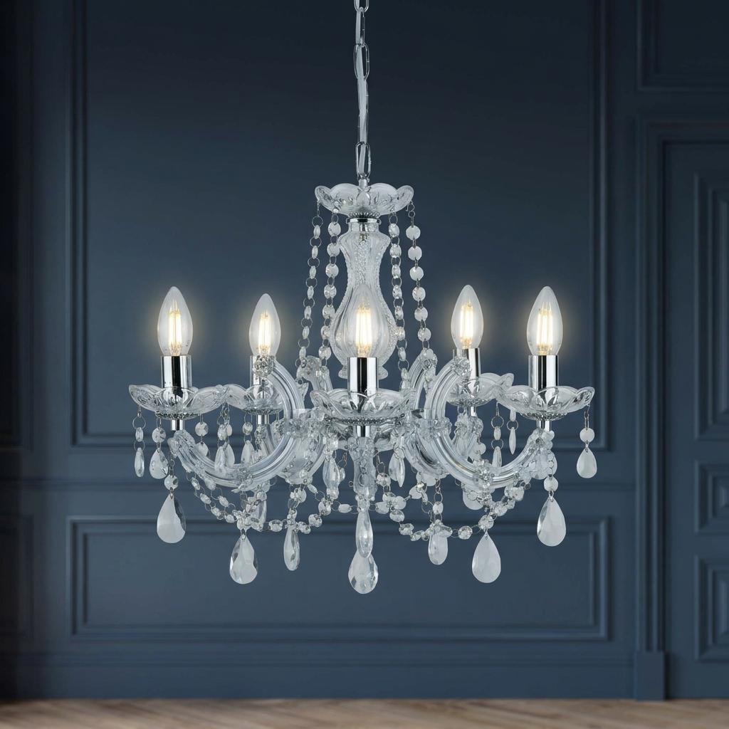 Marie Therese 5 light chrome and crystal glass chandelier with hanging droplets against a dark blue paneled wall.