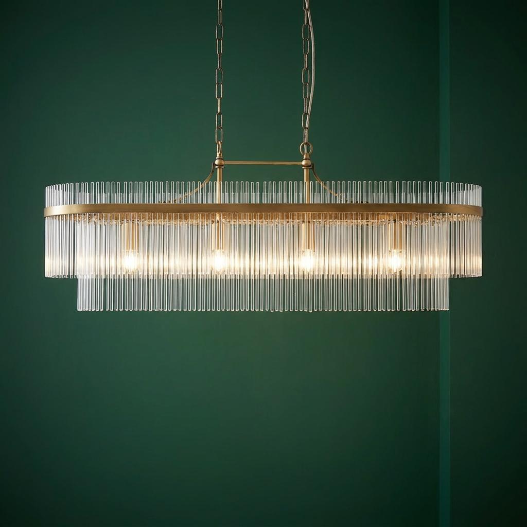 Marietta brass 4-light linear pendant with vertical glass rods illuminated against a dark green wall.