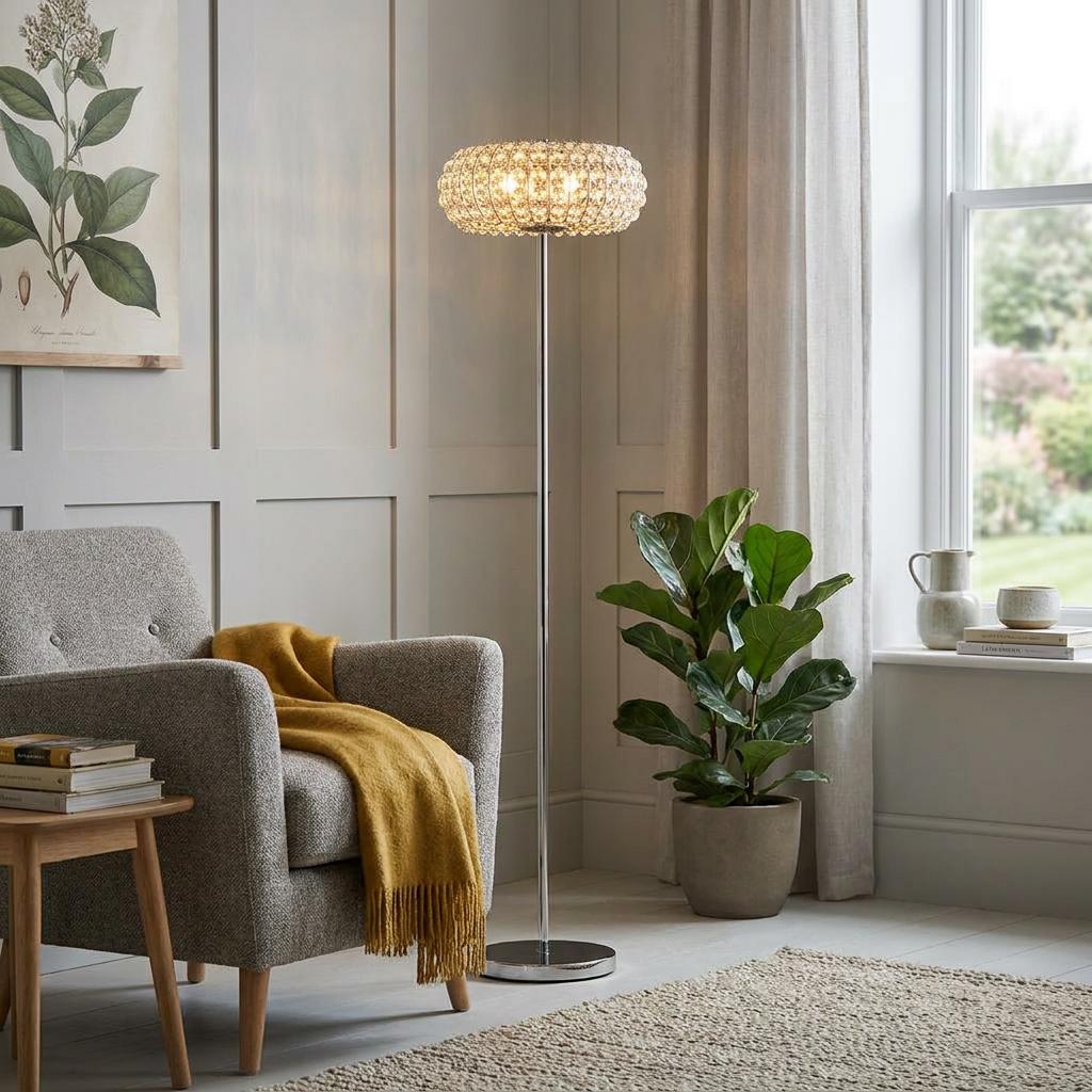 Marilyn modern chrome floor lamp with a crystal beaded shade, standing in a living room next to a grey armchair.