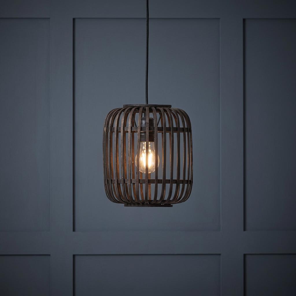 Mathias adjustable ceiling pendant featuring a dark bamboo cage shade and glowing bulb against a paneled wall.