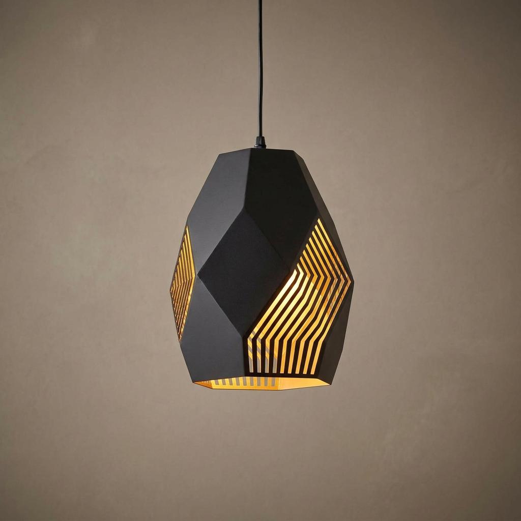 Geometric black pendant light with laser-cut slits revealing a glowing gold interior against a textured wall.