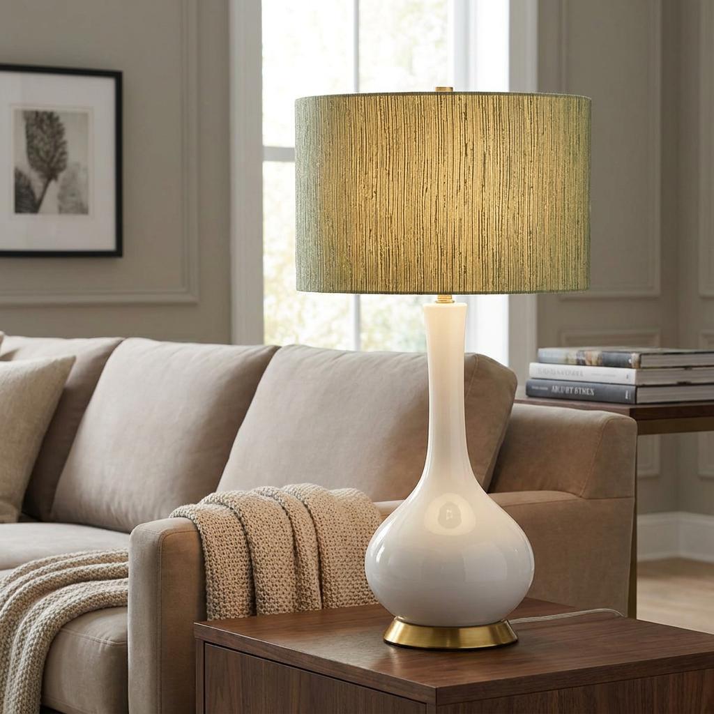 Milo White Ceramic Table Lamp with a textured green shade on a wooden side table in a living room.