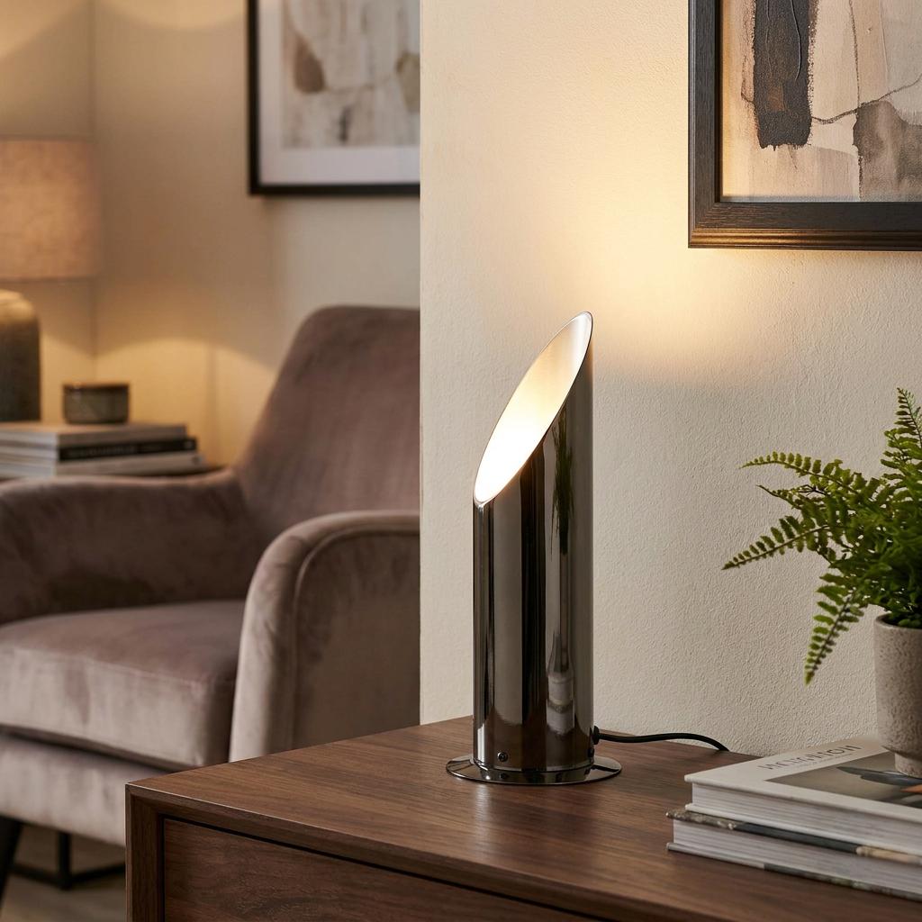 Mini Antique Mirror Black Uplighter lamp on a wooden sideboard casting a warm glow in a living room.