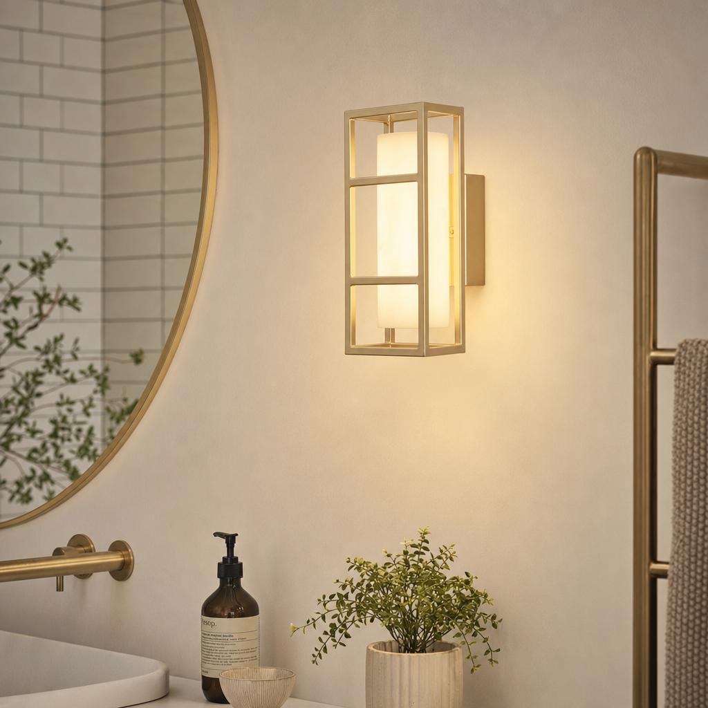 Modern matt gold LED bathroom wall light with a rectangular frame and frosted glass diffuser on a beige wall.