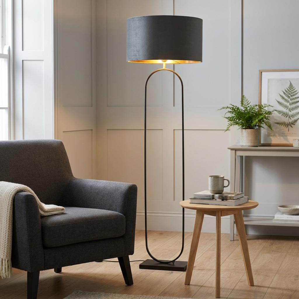Modish floor lamp with a black metal frame and dark grey shade illuminating a cozy living room nook.