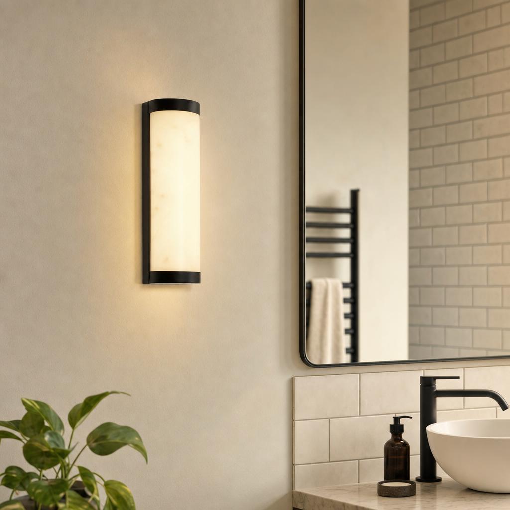 Vertical matte black LED wall light with a soft glow, mounted on a neutral wall in a modern bathroom.