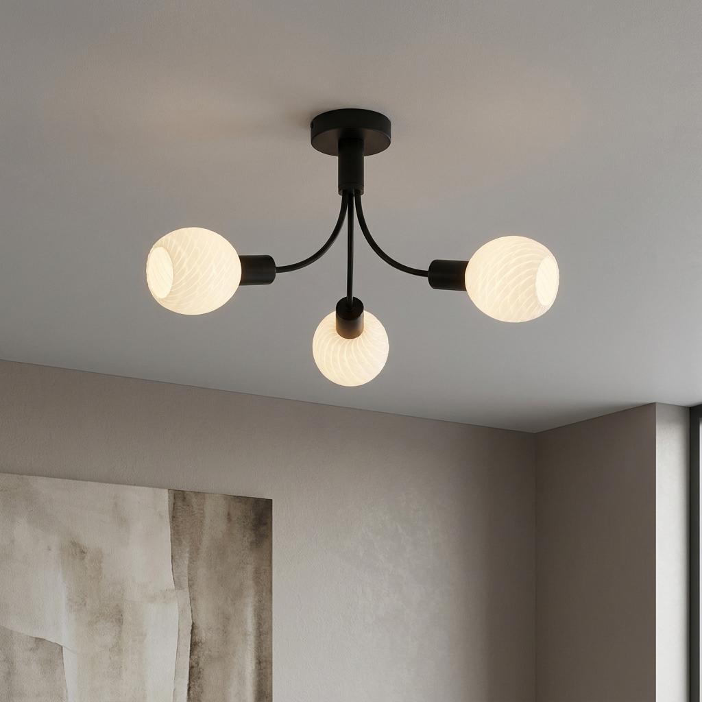 Modern black three-arm ceiling lamp with frosted glass globe shades mounted on a white ceiling.