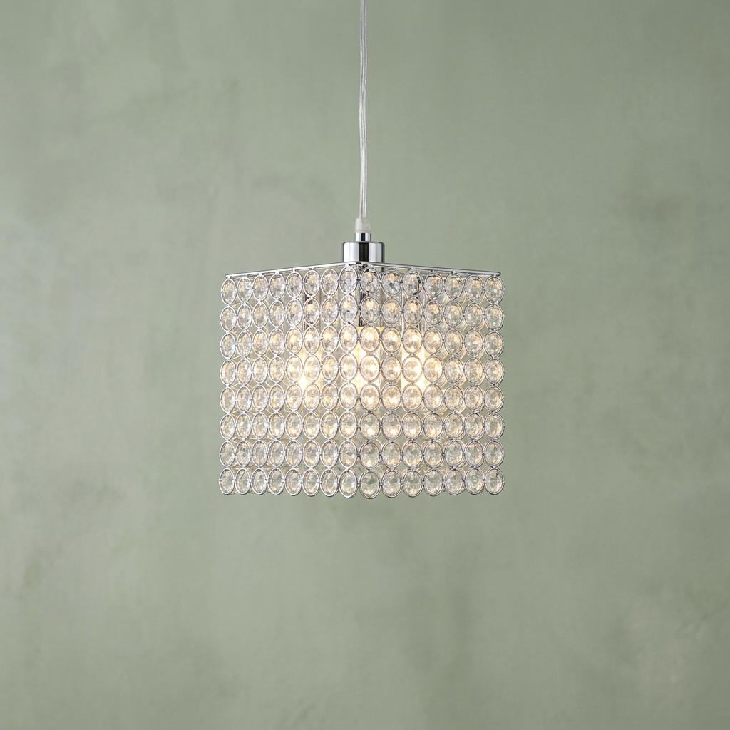 Cube-shaped pendant light with clear glass beads in a chrome frame against a soft green textured wall.