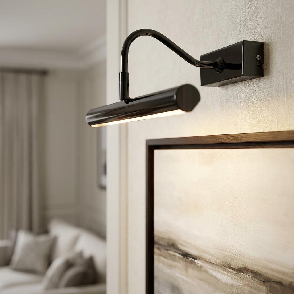 Sleek black LED picture light with a curved arm illuminating a framed painting in a modern interior.
