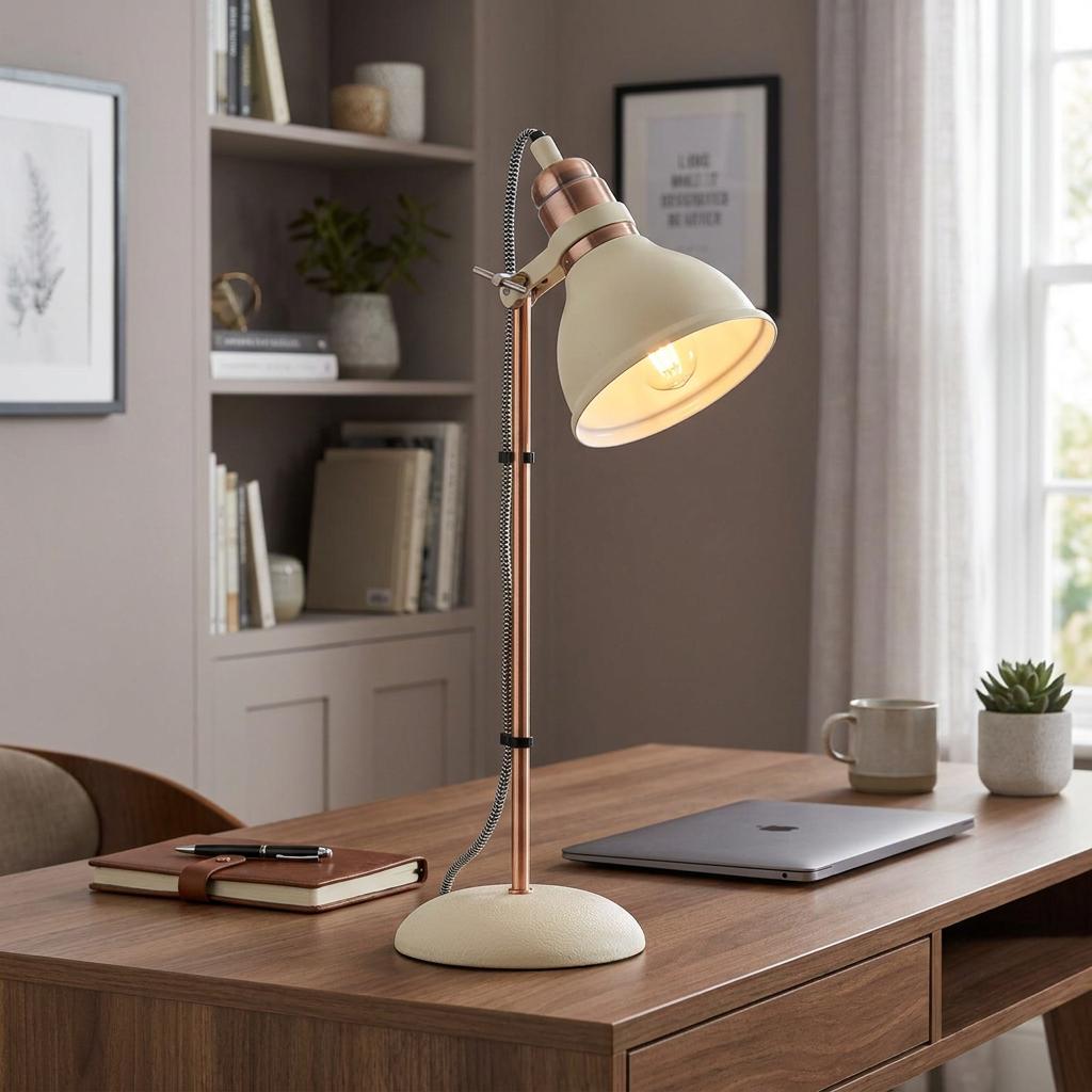 Cream and copper desk lamp with an adjustable neck illuminates a wooden office desk in a modern study.