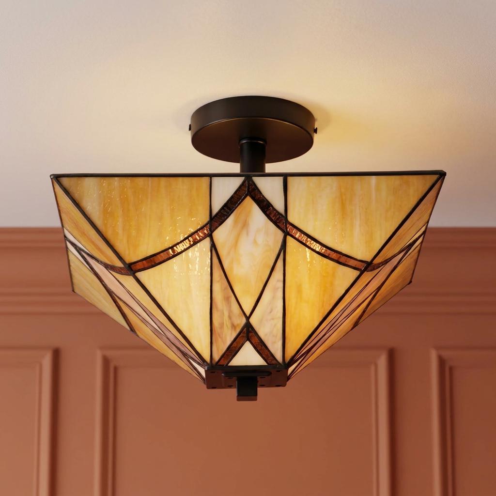 A Tiffany-style semi-flush ceiling light with a geometric amber glass shade against a terracotta paneled wall.