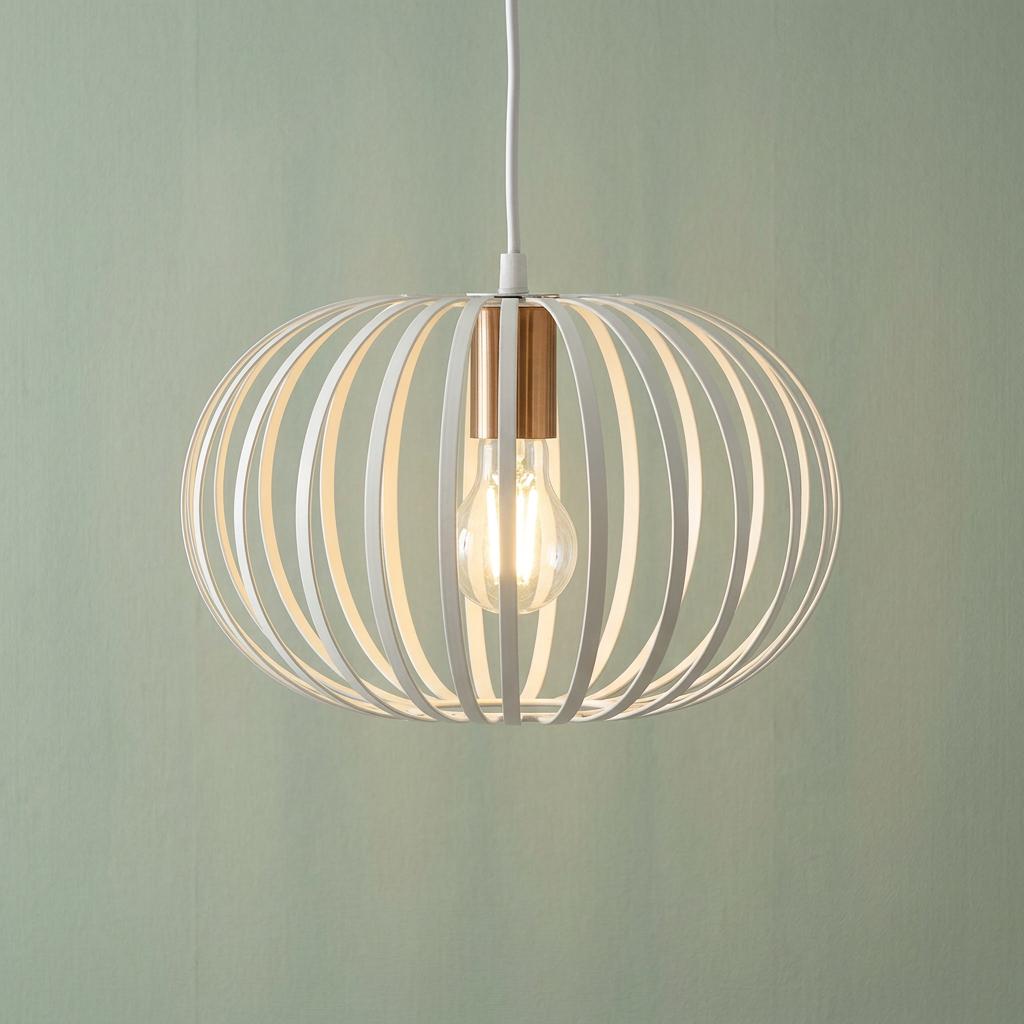 White wire-frame oval ceiling pendant with a brass cap and lit bulb against a soft green background.