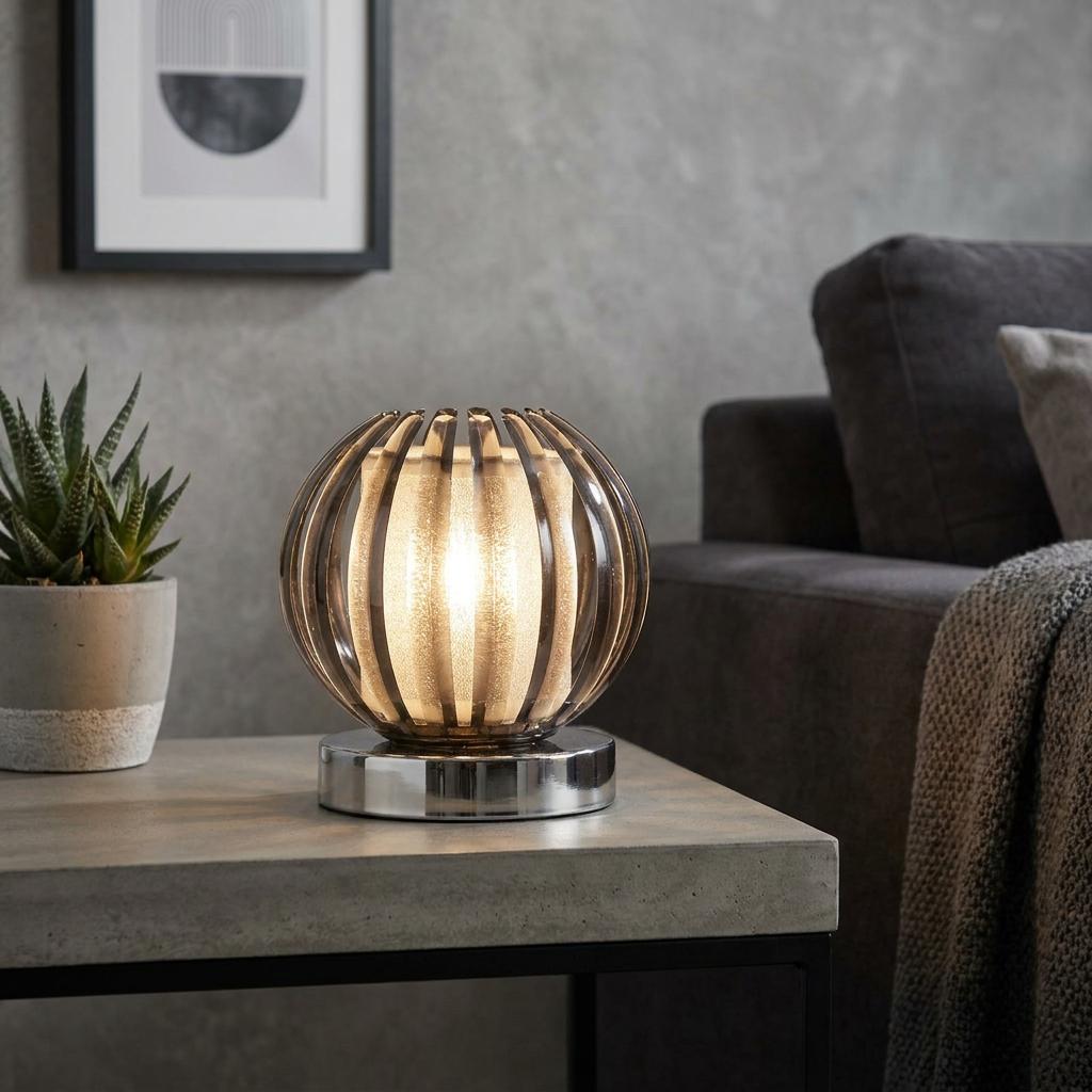 Glowing sphere-shaped touch lamp with smoked acrylic slats on a concrete table in a modern living room.