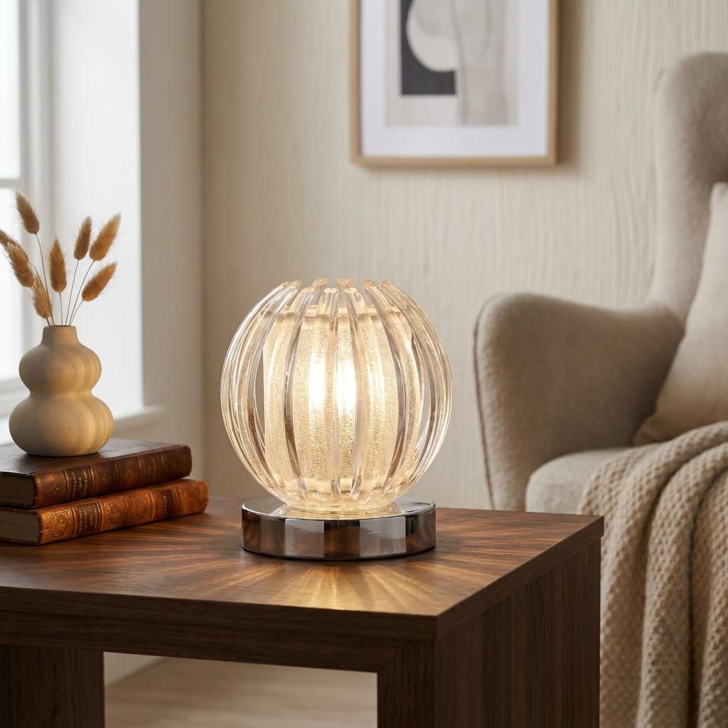 Glowing ribbed clear acrylic globe table lamp on a wooden side table in a cozy living room.