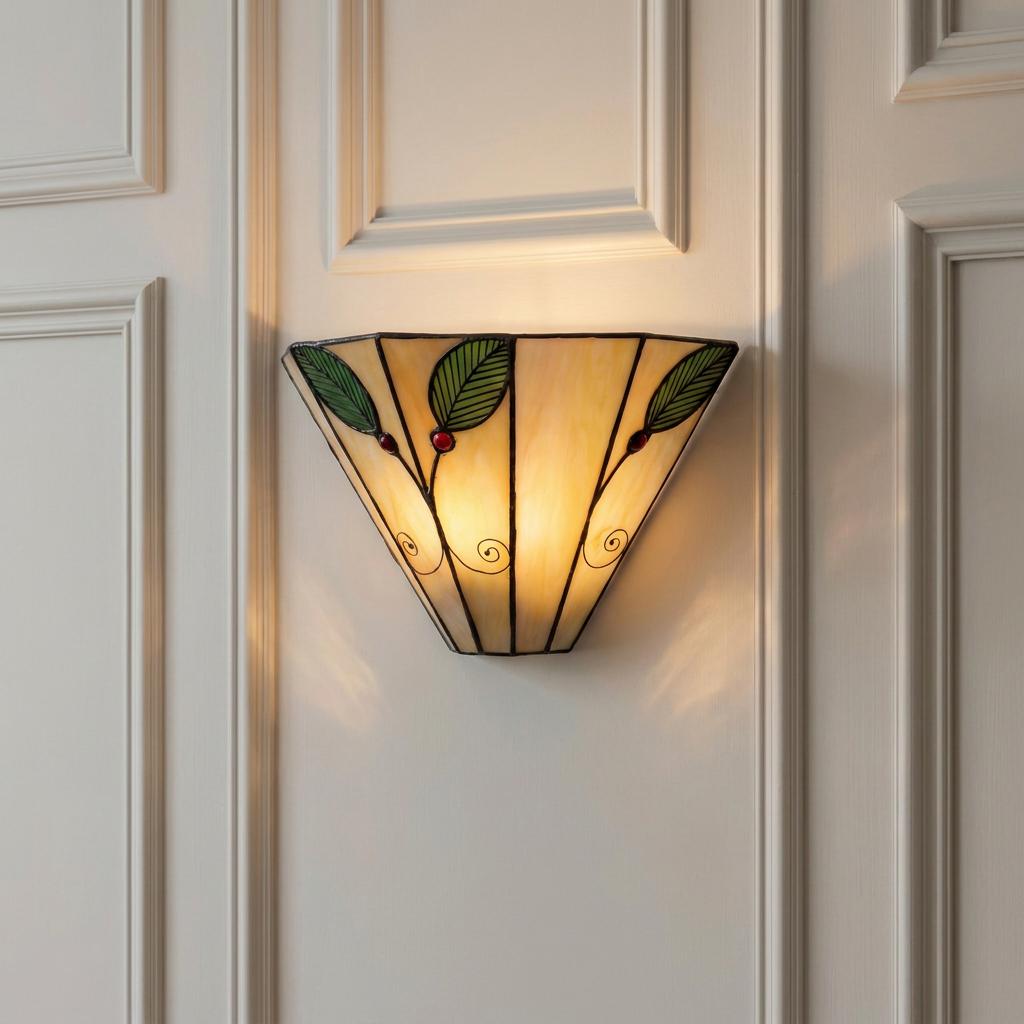 A Tiffany-style wall light with green leaf and red berry glass motifs mounted on a white panelled wall.