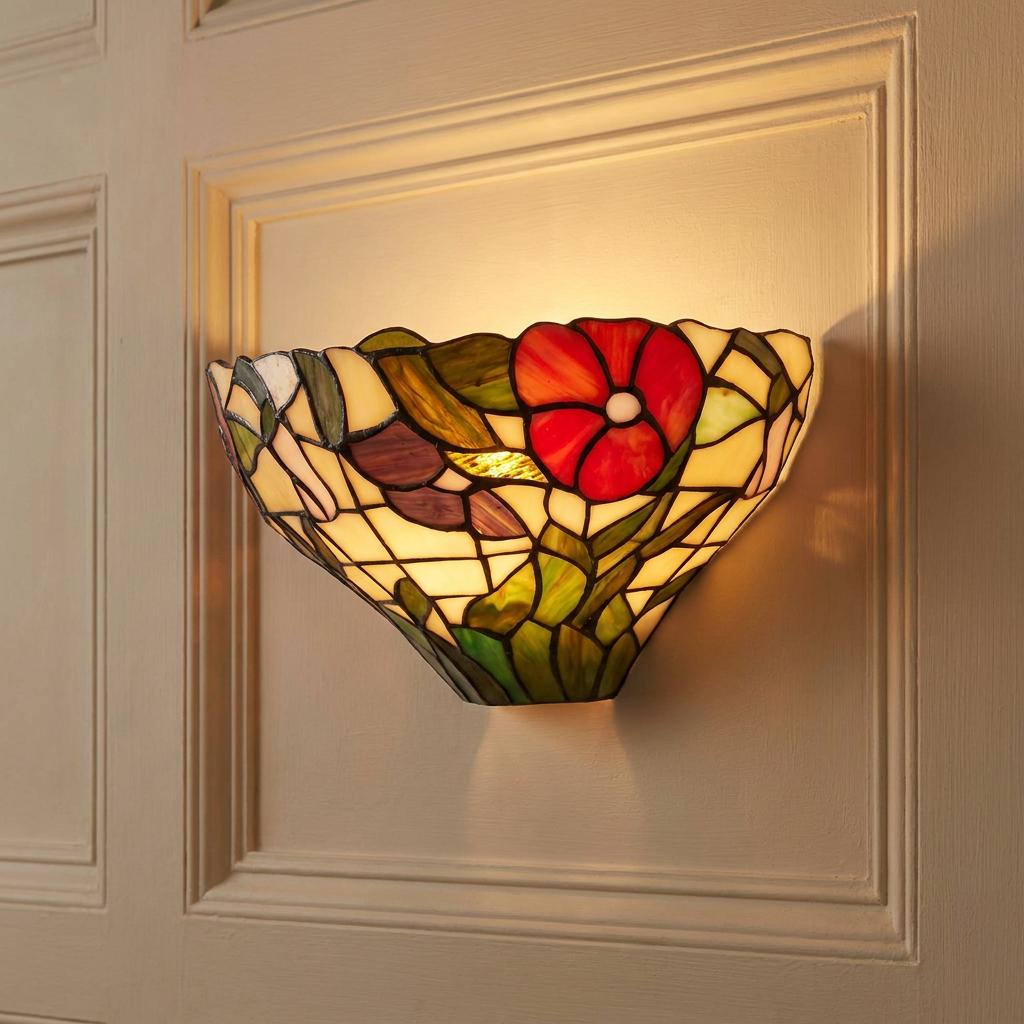 Illuminated Tiffany wall light with a red peony stained glass design mounted on a cream paneled wall.