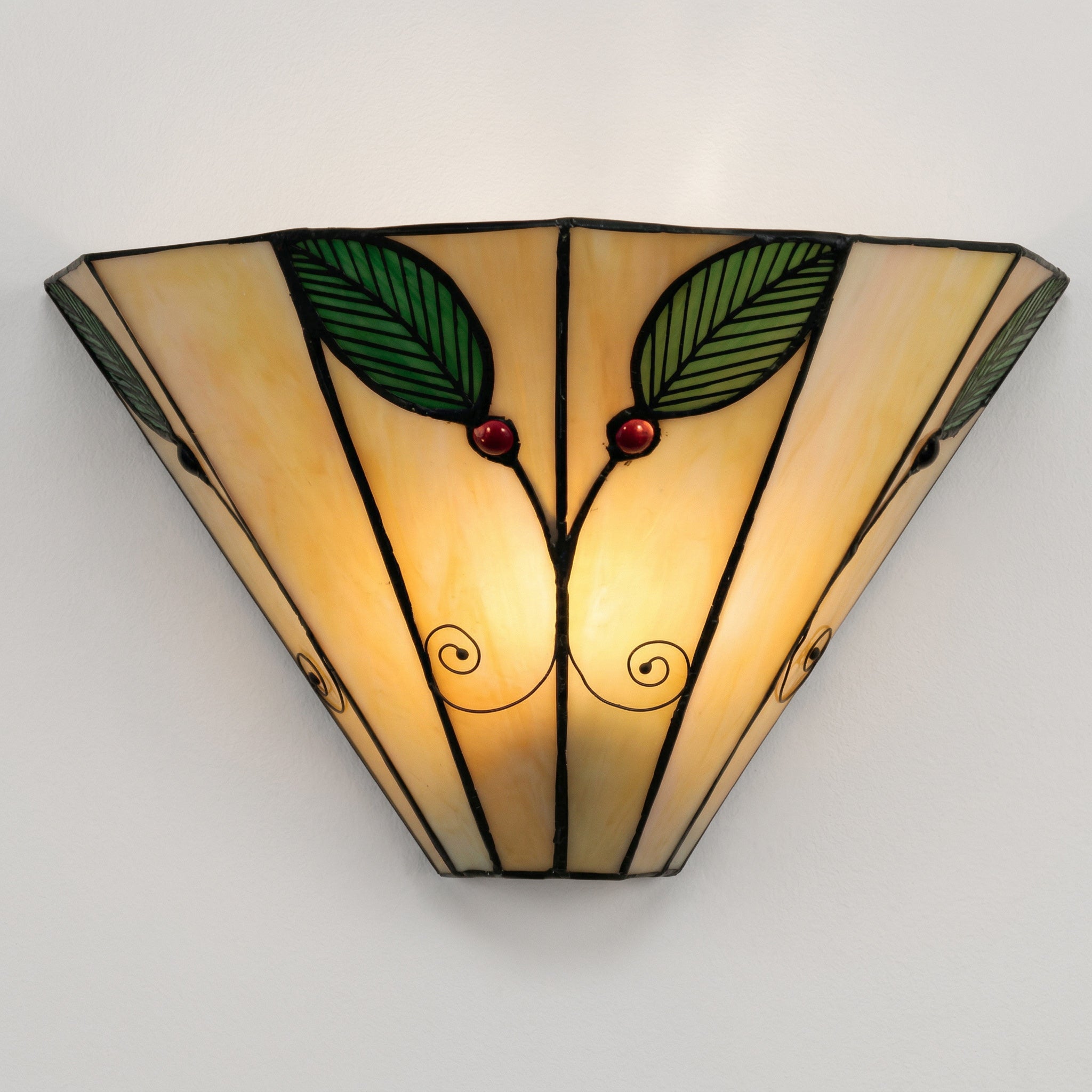 Decorative wall light fixture with leaf and berry design on a plain background