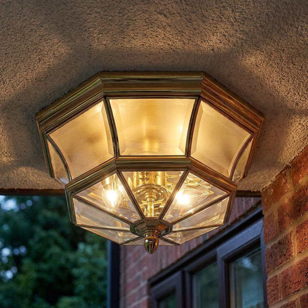 Octagonal brass outdoor flush mount ceiling light with glass panels, glowing warmly under a porch overhang.