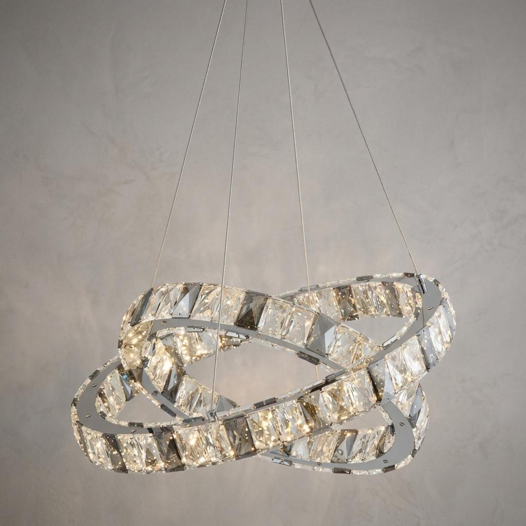 Two interlocking rings of clear and smoky faceted crystals illuminated from within, suspended by thin wires.