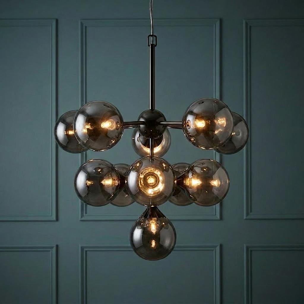 Modern black 11-light pendant with smoked glass globe shades against a teal paneled wall.