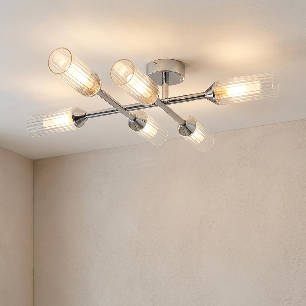 Six-light chrome semi-flush ceiling fixture with ribbed glass shades emitting a warm glow on a neutral ceiling.