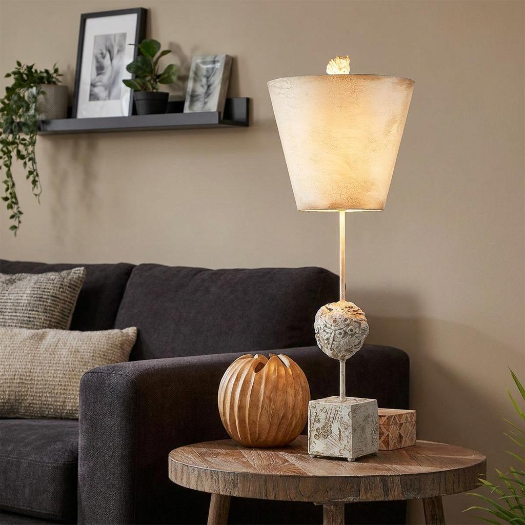 Petra Bone White Table Lamp featuring a textured orb stem and distressed shade, sitting on a wooden side table.