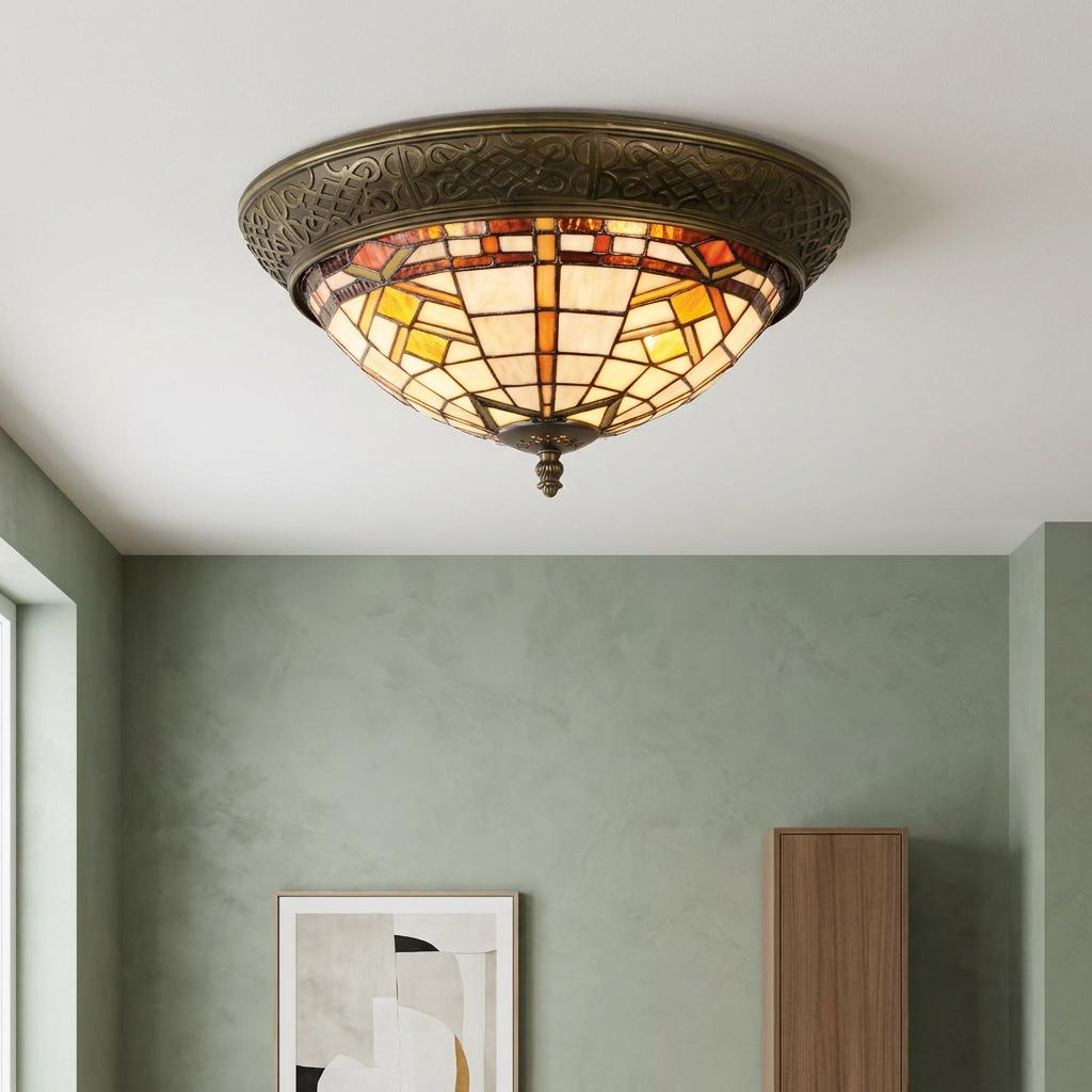 Tiffany style flush ceiling light with geometric brown and beige glass on an ornate bronze mount in a green room.