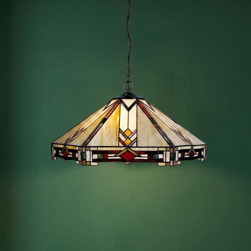 Large Tiffany-style pendant light with geometric stained glass shade hanging against a green wall.