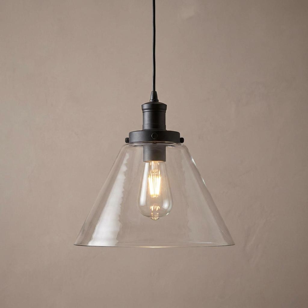 Black ceiling pendant light with a clear pyramid glass shade and an illuminated vintage bulb.