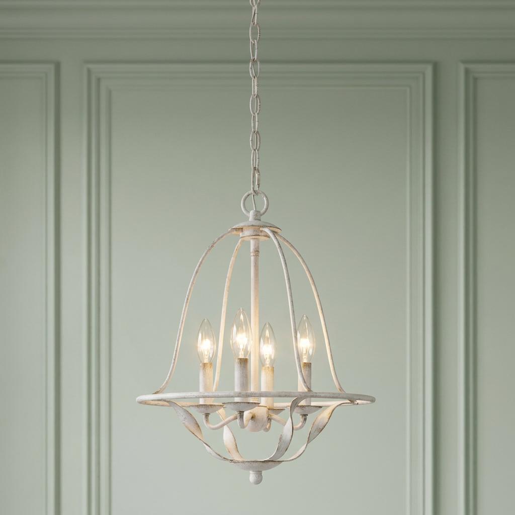 Antique white four-light pendant chandelier with a curved cage design against a pale green paneled wall.