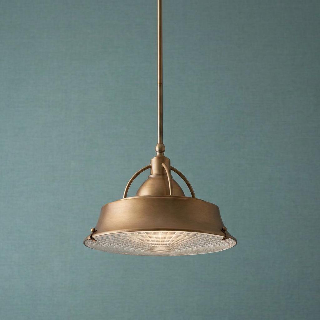 A copper pendant light with a textured glass diffuser hangs against a blue-green textured wall.