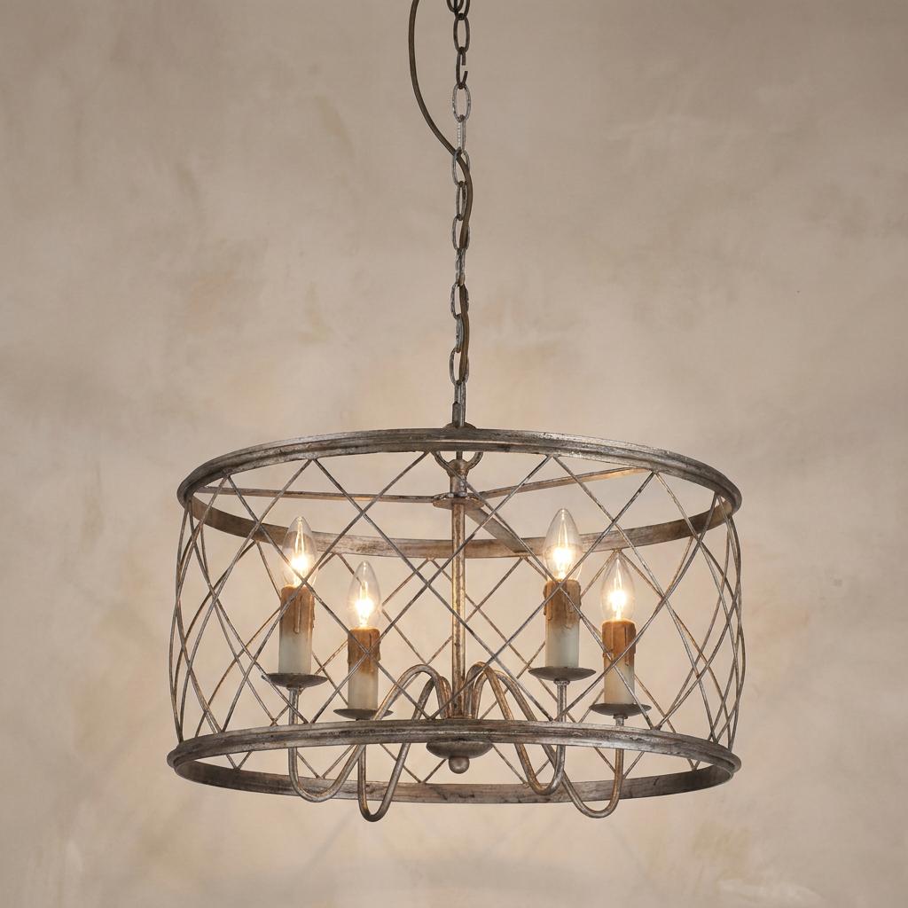 Silver lattice drum pendant chandelier with four candle-style lights against a neutral, textured wall.