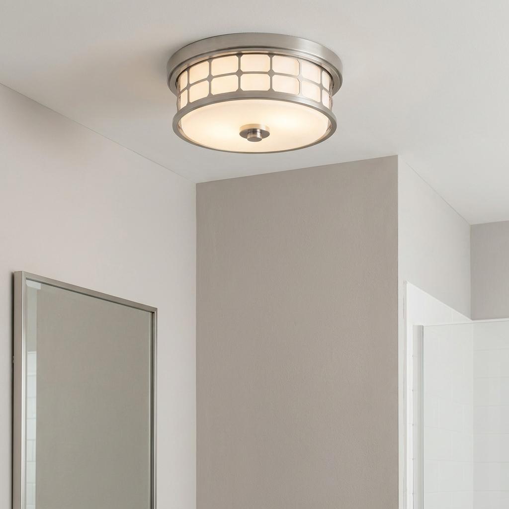 Brushed nickel flush mount ceiling light with a white lattice glass shade installed in a neutral-toned bathroom.