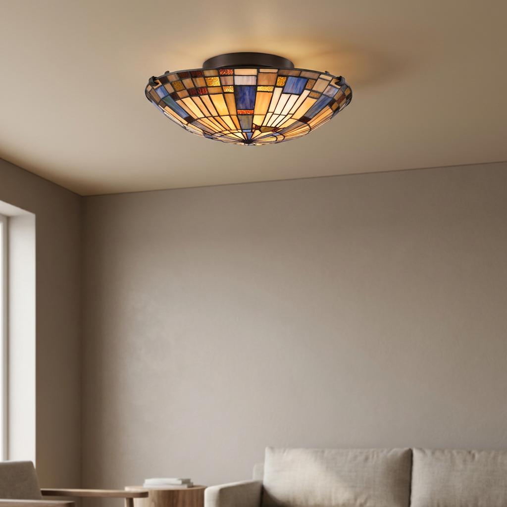 Geometric Tiffany-style flush mount ceiling light with amber and blue stained glass in a neutral living room.