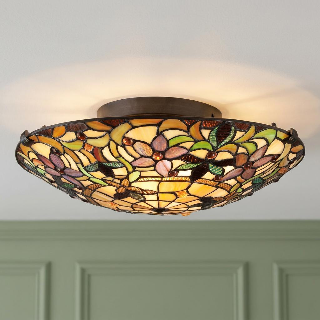 Warmly glowing Tiffany-style flush mount ceiling light with a purple and green floral stained glass shade.