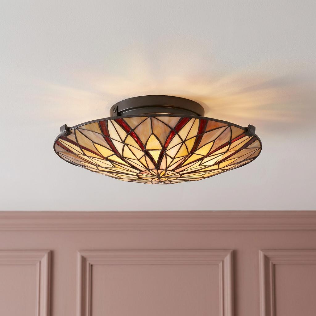 Circular Tiffany semi-flush ceiling light with geometric stained glass floral pattern.