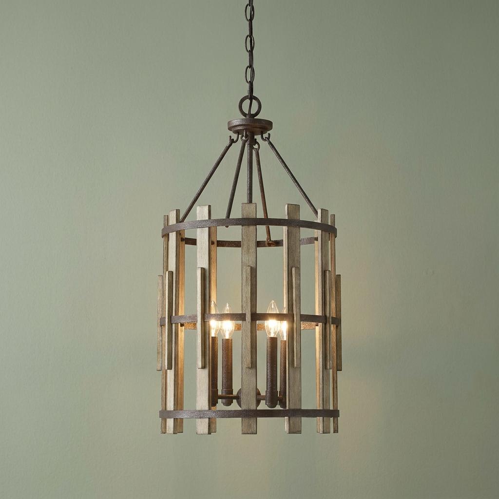 Rustic 4-light chandelier with wood slats and dark metal bands hanging against a sage green wall.