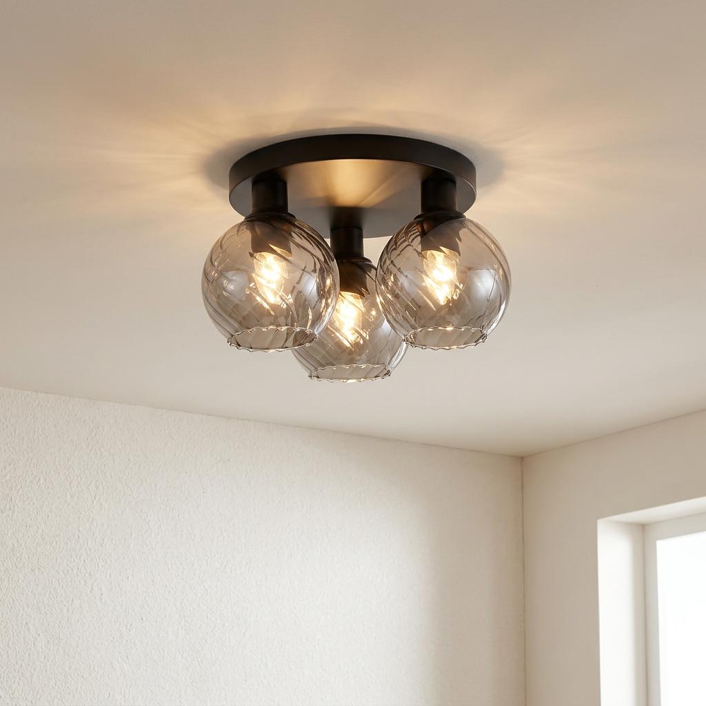 A black metal flush ceiling light with three glowing swirl glass globes mounted on a white ceiling.