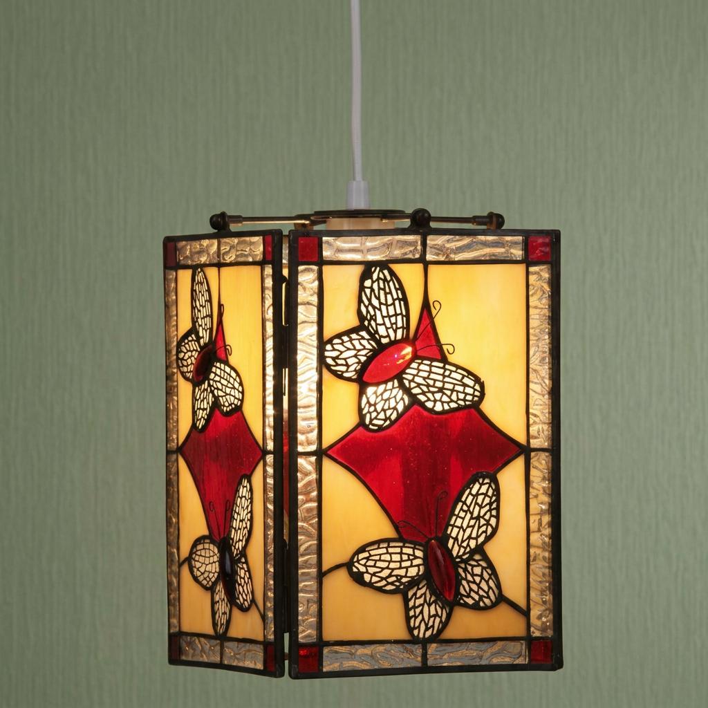 Stained glass Tiffany ceiling lamp shade with red butterfly motifs on a yellow background hanging from a white cord.