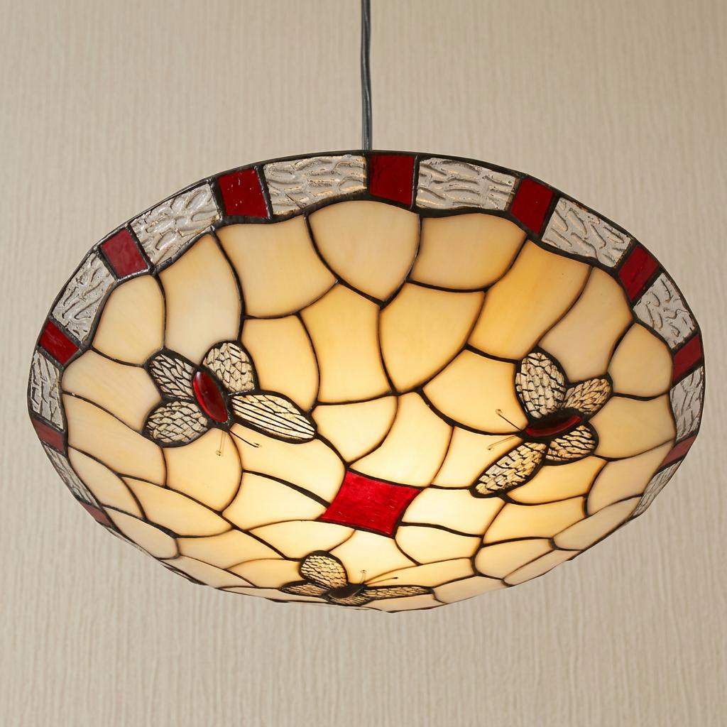 Red and cream Tiffany style round ceiling lamp shade featuring butterfly patterns lit against a neutral wall.