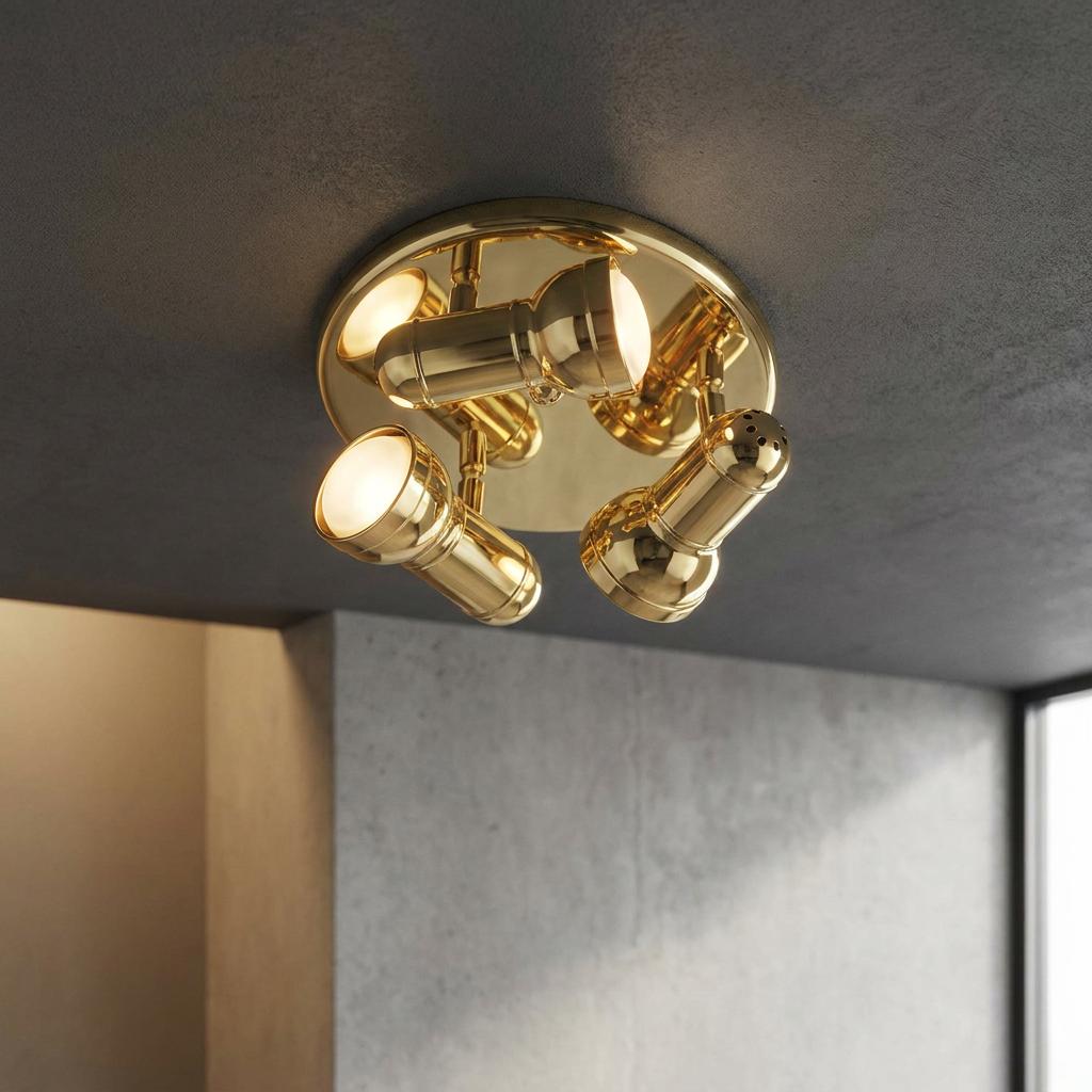 Polished brass triple spotlight fixture with adjustable glowing heads mounted on a dark textured ceiling.