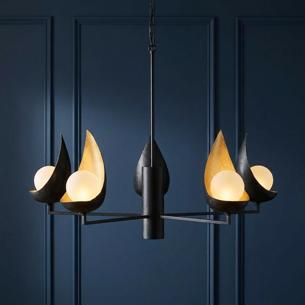 Modern black chandelier with five gold-lined leaf shades and white globe lights against a blue paneled wall.