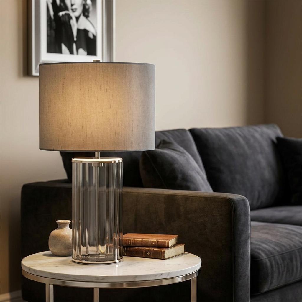 Reno Smoked Glass & Polished Nickel Table Lamp with a grey shade on a marble side table in a living room setting.